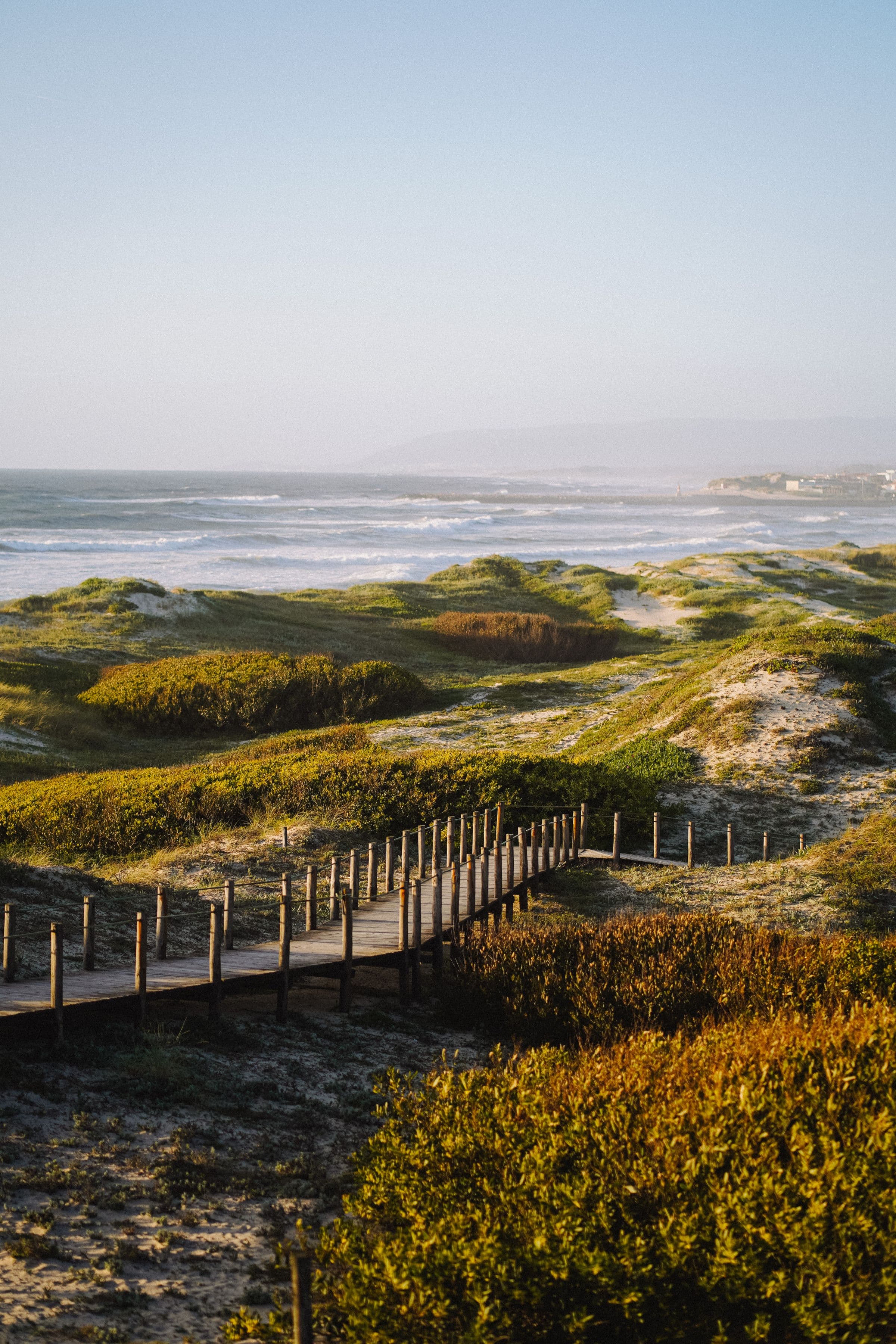 Wooden boardwalk leading across coastal sand dunes toward the Gulf surf